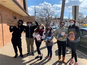 Key club students and kiwanis volunteers holding food to distribute to residents in Clifton 