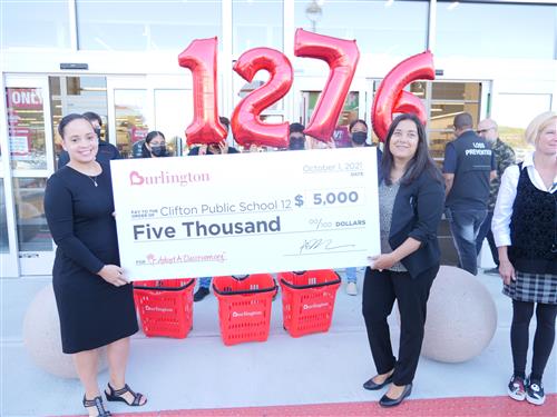 Ms. Rey and Mrs. Kenning receiving a giant check for $5000 from Burlington Stores