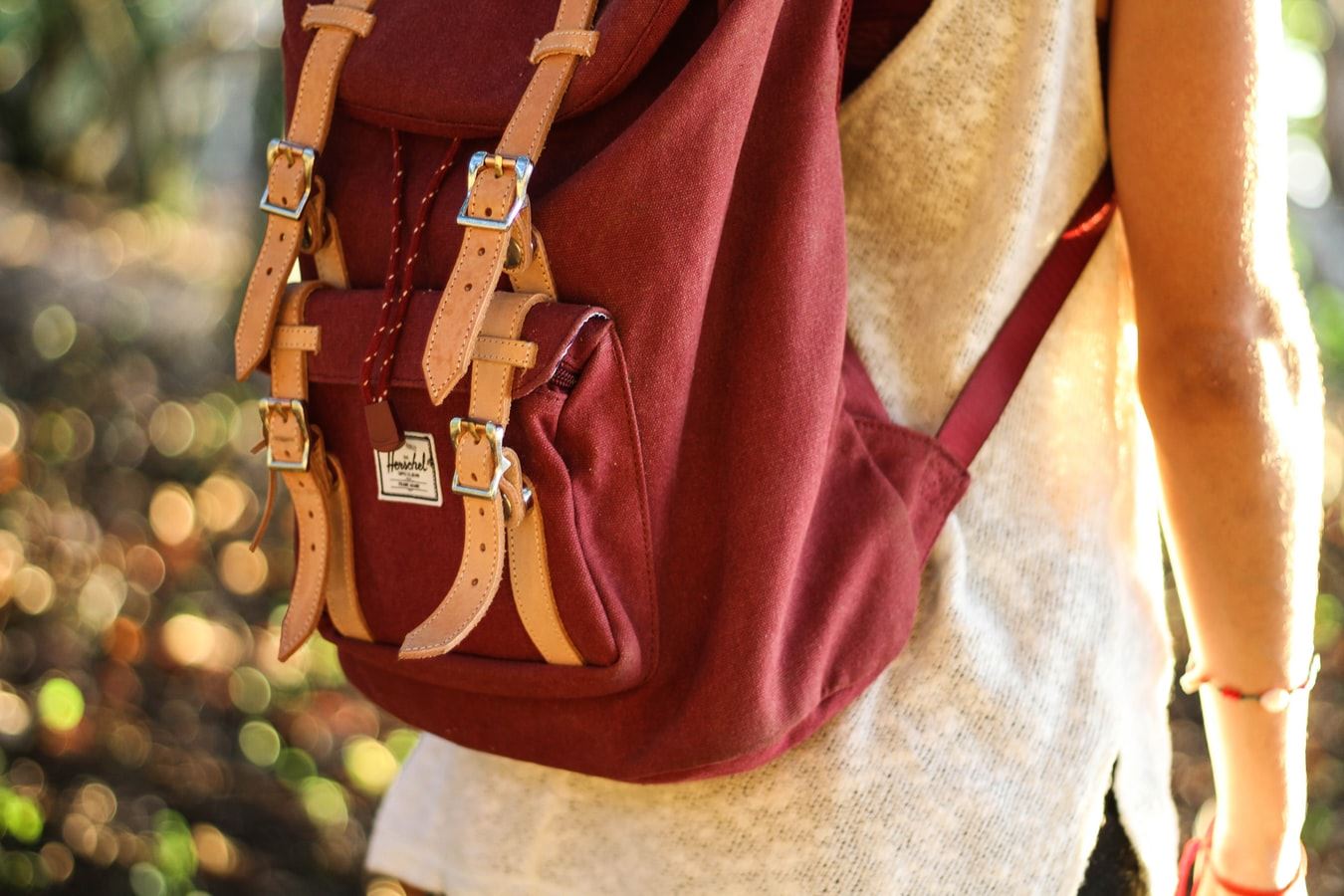 A person walking with red backpack on